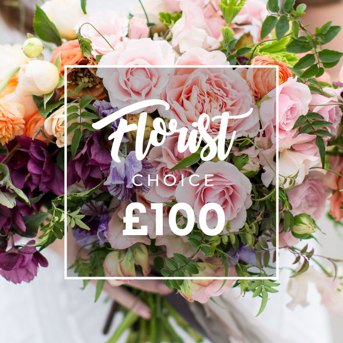 A richly textured, hand-tied bouquet fills the image, the composition caught in flattering, diffused light that celebrates both colour and craft. Several large, soft pink garden roses form the focal cluster, their velvety, ruffled petals resembling peony crowns; surrounding them, dramatic plum and burgundy hellebore-like blooms add depth and shadowed interest. Pale purple-and-white striped sweet peas thread through the arrangement, their delicate, fluttering petals balancing the more substantial peach and coral ranunculus-style flowers. Creamy white accent blooms provide luminous contrast and a sense of air, while abundant greenery - from trailing tendrils to broader, satiny leaves - creates an organic, garden-inspired silhouette. A slim white square overlay sits over the flowers with the graceful text Florist Choice and a bold ?100 displayed beneath, signifying a curated offering. The bouquet is gently held at the base by hands with a faint white sleeve visible, lending a human scale and the intimacy of a hand-delivered gift, the background softly blurred to keep attention on the blooms.Prepared with the sensibility of a local florist, this arrangement reads as both luxurious and approachable - appropriate for weddings, anniversaries, or sympathy - and evokes the quieter corners of Chase Cross and nearby Collier Row where fresh stems are sourced and wrapped. Crafted with seasonal attention, it hints at the scent of roses and green foliage and the careful selection that goes into every hand-tied selection by a neighbourhood maker such as Chase Cross Flowers.
